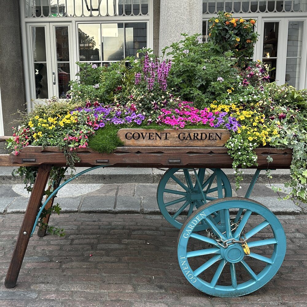 Drewniany wózek z kwiatami i napisem Covent Garden