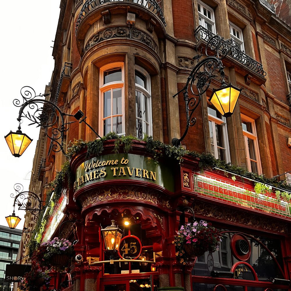 Wieczorny londyński pub z latarniami i kwiatami
